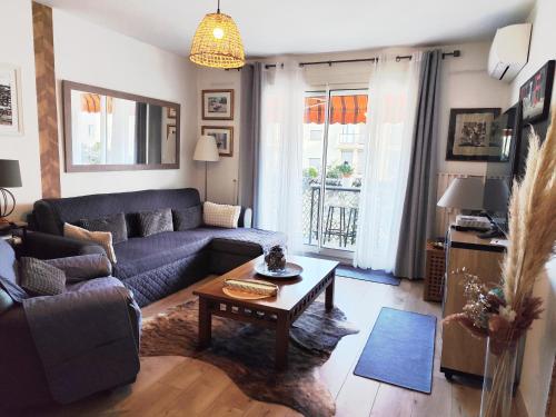 a living room with a couch and a table at Le balcon de la basse centre ville de Perpignan in Perpignan