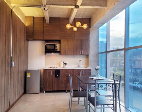 a kitchen with a table and chairs and a kitchen with a window at The Hub by Wynwood House in Medellín
