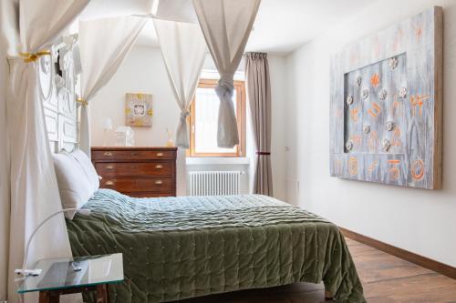 a bedroom with a bed and a dresser and a window at Museo Grillo Camere d'Arte, dormire nel Museo in Arena Po