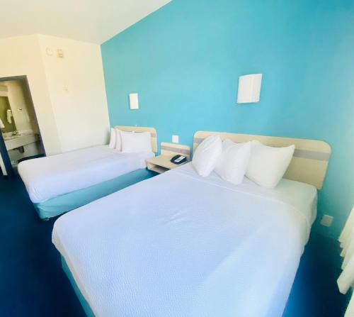 a hotel room with two beds and a blue wall at Motel 6-Red Deer, AB in Red Deer