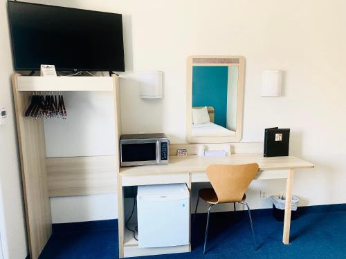 a room with a desk with a television and a mirror at Motel 6-Red Deer, AB in Red Deer