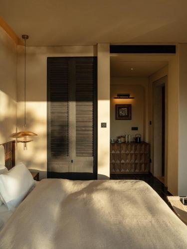 a bedroom with a large white bed in a room at 大理空山语 风眠艺术海景酒店 Dali Kongshanyu Art Seaview Hotel in Dali Airport