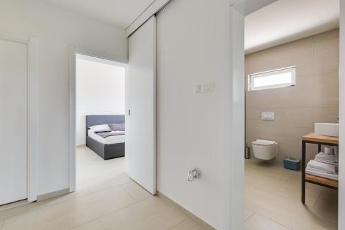 une chambre avec un lit et une porte coulissante en verre dans l'établissement Villa Kotari in Zemunik Gornji - Haus für 10-12 Personen, à Simurina