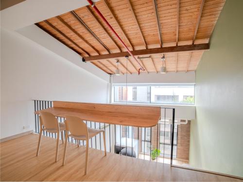 a dining room with a wooden table and chairs at Enchanted Elegance in Laureles in Medellín