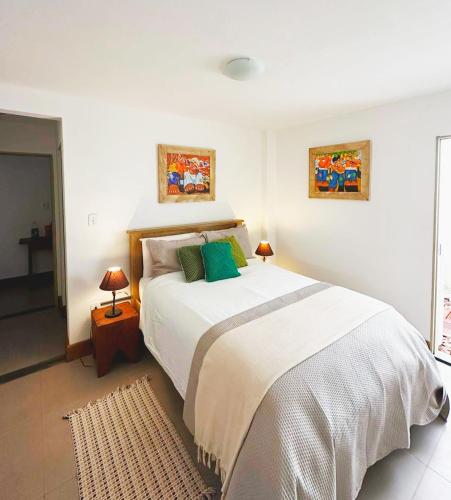 a bedroom with a large white bed with green pillows at Casa Dona Luiza 166, Centro, Mountain views in Passa Quatro