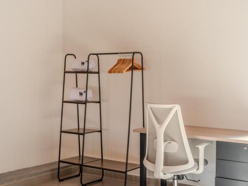 a white chair sitting next to a desk with two shelves at Enchanted Elegance in Laureles in Medellín