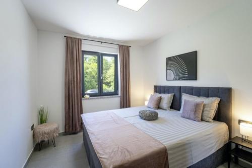 ein Schlafzimmer mit großem Bett und Fenster in der Unterkunft Villa Milena in Blaškovići - Haus für 8 Personen in Polje Čepić