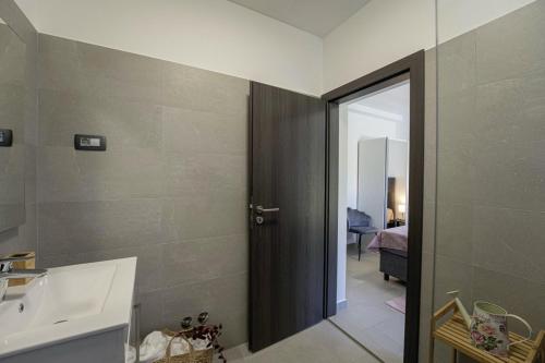 ein Bad mit einem Waschbecken und einer Tür zu einem Zimmer in der Unterkunft Villa Milena in Blaškovići - Haus für 8 Personen in Polje Čepić