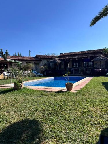 a house with a swimming pool in a yard at Le petit Olivier 