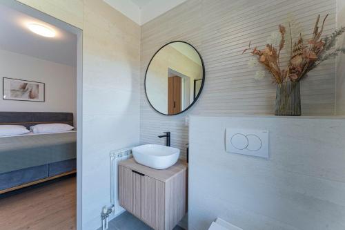 a bathroom with a sink and a mirror on the wall at Villa Rita in Pinezići - Haus für 5 Personen in Marčana