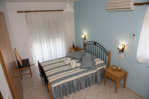 1 dormitorio con cama, mesa y ventana en Nephele Apartments en Faliraki