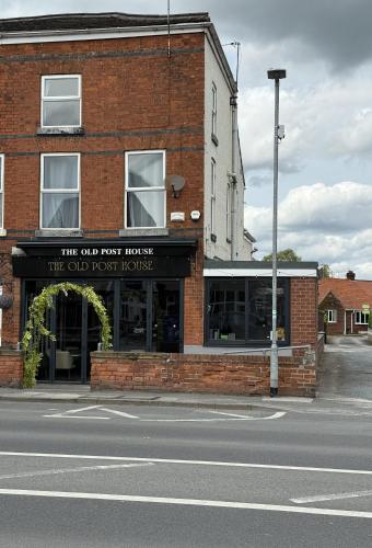 a brick building with a sign that reads the old fossil house at The Old Posthouse in Scalby