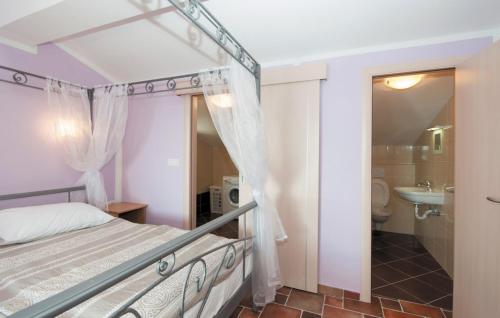 ein Schlafzimmer mit einem Bett und ein Badezimmer mit einem Waschbecken in der Unterkunft Villa Davorka in Supetarska Draga - Haus für 8 Personen in Supetarska Draga