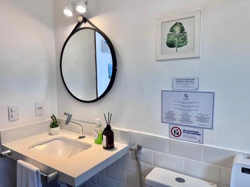 a bathroom with a sink and a mirror at Bella Buzios Apartamentos in Búzios