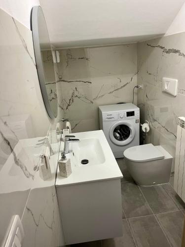 a bathroom with a sink and a washing machine at Villetta Dolce Vigna in Lucca