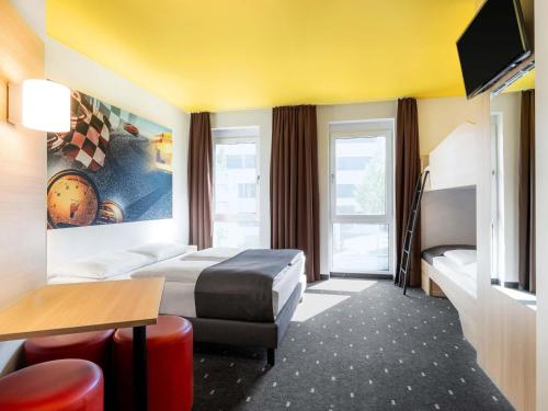 a hotel room with a bed and a television at B&B Hotel Stuttgart-Zuffenhausen in Stuttgart