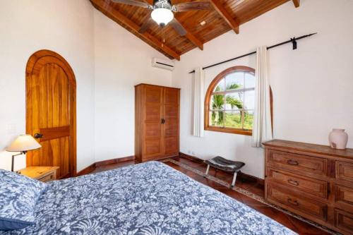 a bedroom with a blue bed and a window at Casa Amarilla in Playa Hermosa