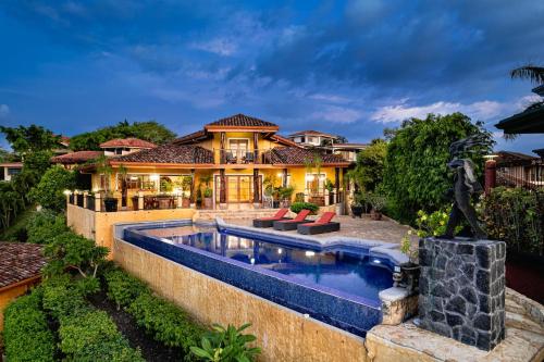 a house with a swimming pool in front of it at Casa Amarilla in Playa Hermosa