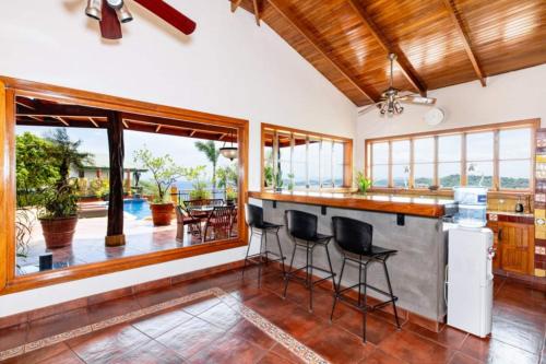a kitchen with a bar and a view of a patio at Casa Amarilla in Playa Hermosa
