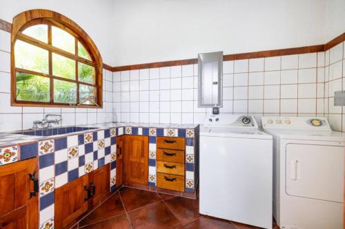 a kitchen with a washer and dryer in it at Casa Amarilla in Playa Hermosa