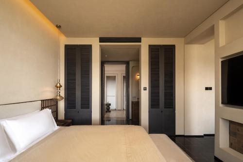 a bedroom with a bed and a flat screen tv at 大理空山语 风眠艺术海景酒店 Dali Kongshanyu Art Seaview Hotel in Dali Airport