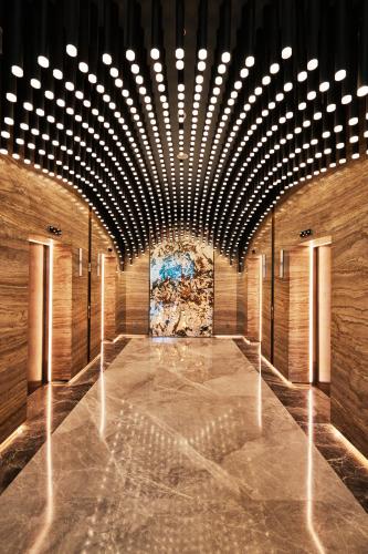 a hallway with a row of lights and a painting at TRIMULIA Hotel in Sihanoukville