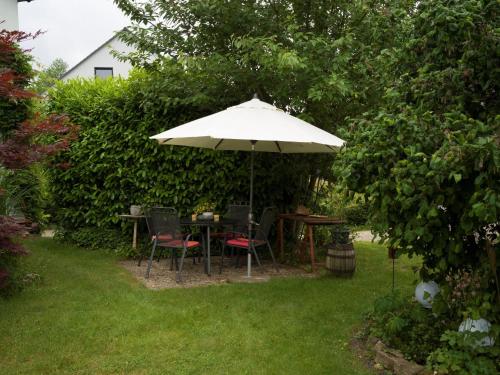 a table and chairs under an umbrella in a garden at Ferienwohnung Katja in Blieskastel in Blieskastel