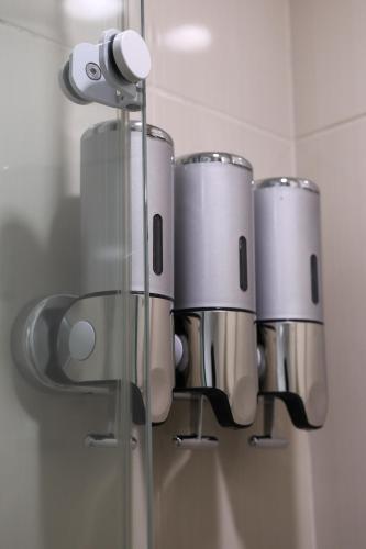 a group of silver cups in a bathroom mirror at BOOK A FLAT Alameda Lorena Jardins in Sao Paulo