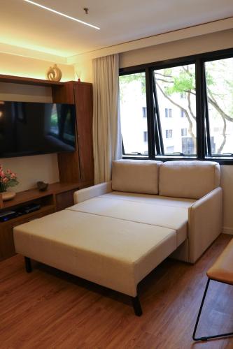 a living room with a couch and a tv at BOOK A FLAT Alameda Lorena Jardins in Sao Paulo