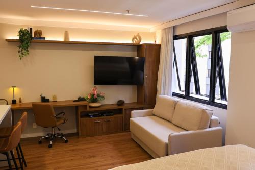 a living room with a couch and a desk with a television at BOOK A FLAT Alameda Lorena Jardins in Sao Paulo