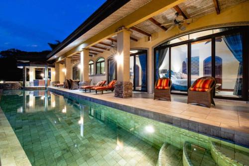 a house with a swimming pool with chairs at Casa Texvol in Playa Hermosa