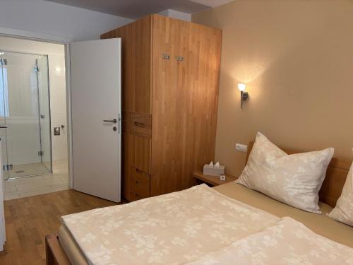 a small bedroom with a bed and a shower at "NATURE erLeben" Appartement & Komfortzimmer in Velden am Wörthersee