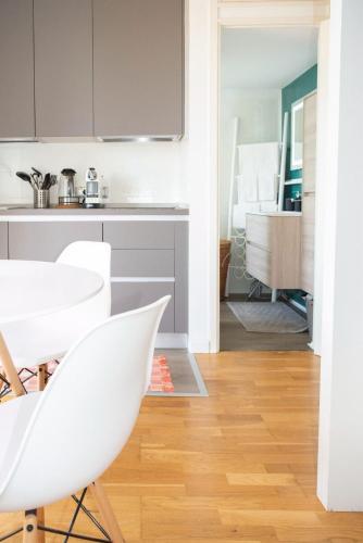 a kitchen with white chairs and a dining room at Tajani Room in Milan