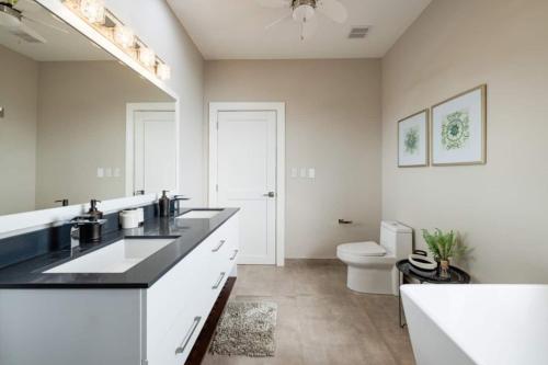 a white bathroom with two sinks and a toilet at Casa Cito in Playa Hermosa