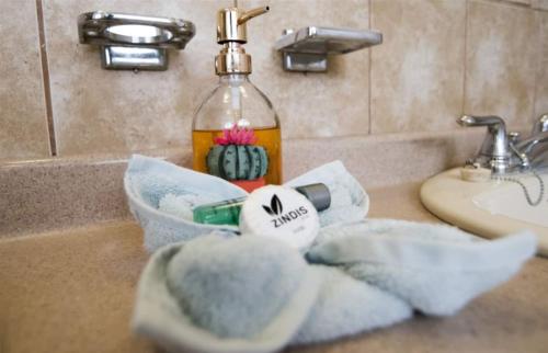a bathroom sink with towels and a bottle of alcohol at Casa De Gigi in Playa Hermosa