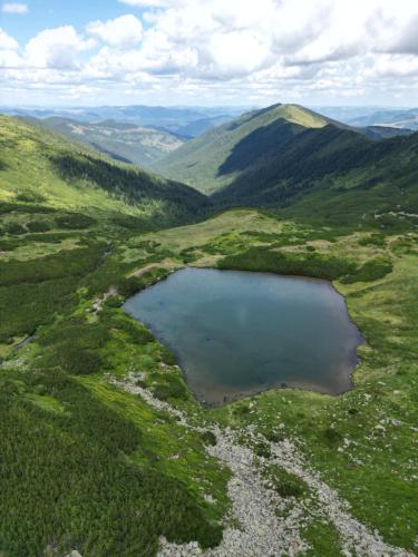 an aerial view of a mountain lake in a valley at Hanul și Păstrăvăria Țibău in Cîrlibaba