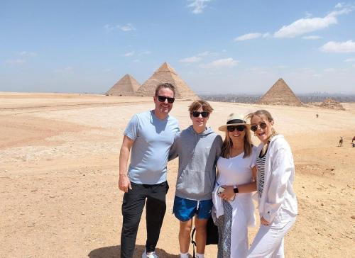 a group of people standing in front of the pyramids at Pyramids golden rocks inn in Cairo
