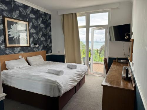 a bedroom with a large bed and a window at Diamond Hotel in Torquay