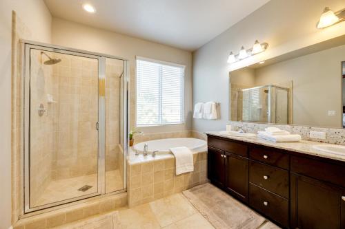 a bathroom with a shower and a tub and a sink at Group Getaway 5 Mi to Dtwn Visalia in Goshen