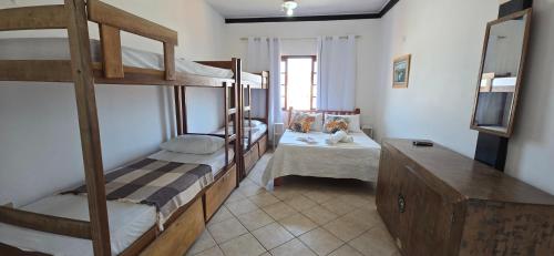a room with two bunk beds and a television at Pousada Mar Dos Anjos in Arraial do Cabo