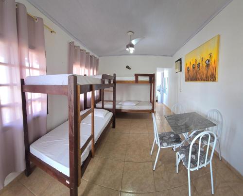 a room with two bunk beds and a table at Pousada Mar Dos Anjos in Arraial do Cabo