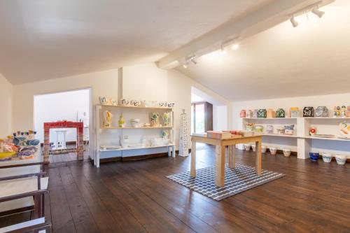 a room with a table and shelves of vases at Museo Grillo Camere d'Arte, dormire nel Museo in Arena Po