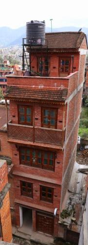 a tall brick building with windows on the side of it at Rehn Homestay in Bhaktapur