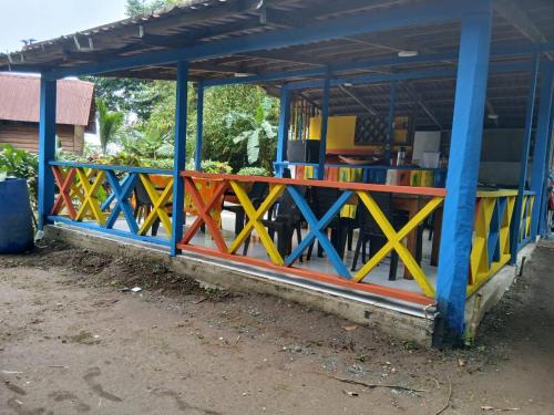 a colorful fence in front of a building at Iracas del Mar in Termales - agua caliente - nuqui