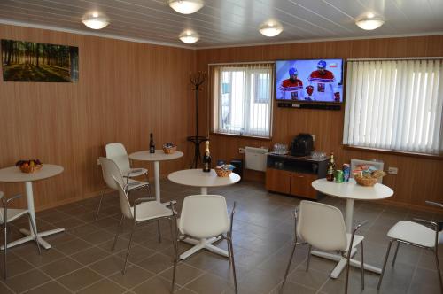 a dining room with tables and chairs and a tv at Комплекс Спасатель in Kartino