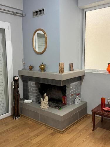 a living room with a fireplace with a mirror at Besa Apartment in Buçimas