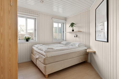 a bedroom with a bed and two windows at The Polar Suite by Paramount in Tromsø