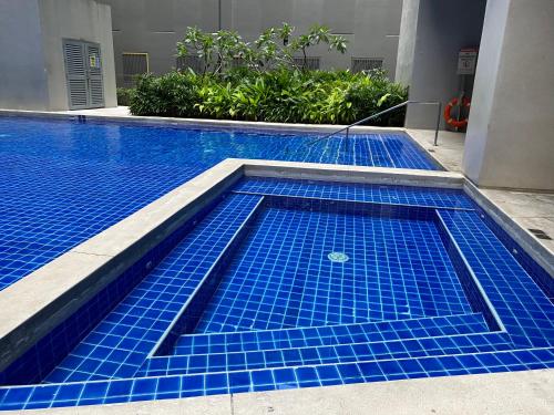 a swimming pool with blue tiles in a building at S Residences Condo PoolView Balcony in SM MOA near NAIA in Manila