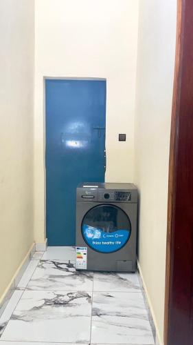 a television sitting in a room with a blue door at Be Confortable in Porto-Novo