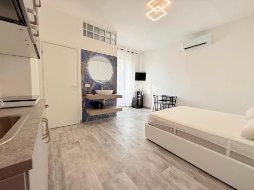 Un dormitorio con una cama y una cocina con fregadero. en Seaside studio, en Torvaianica